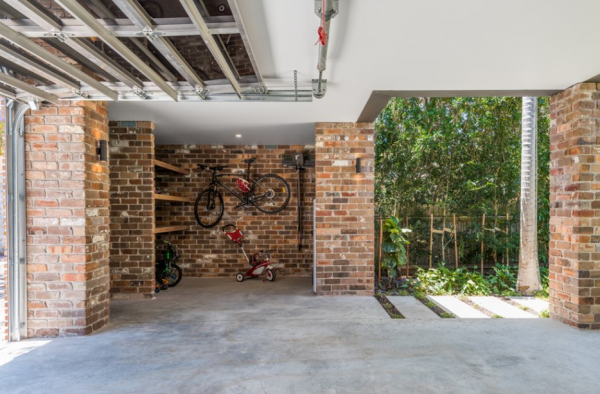 Garasi dengan dinding bata ekspos dan pencahayaan indirek